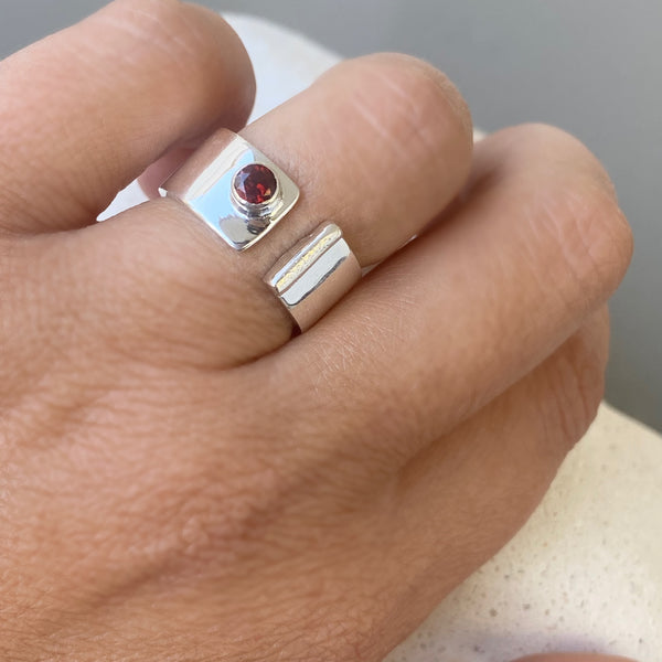 silver ring with a red garnet gemstone 