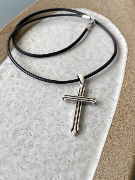 Silver cross necklace with a black leather cord 